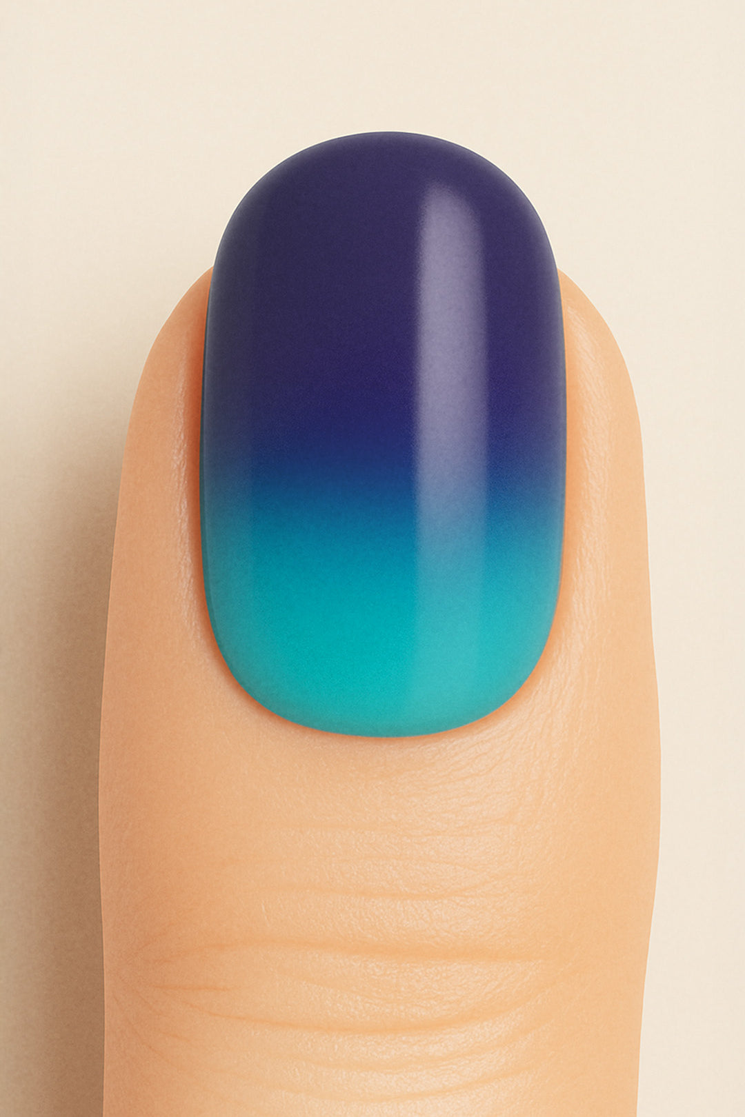 A close-up shot of a model’s finger wearing Ocean Dip Ombre Nail Stickies, showcasing a smooth gradient that blends deep navy blue into aqua teal, highlighting the ocean-inspired tones and glossy salon-like finish that make ombre nails stand out – Muselot.