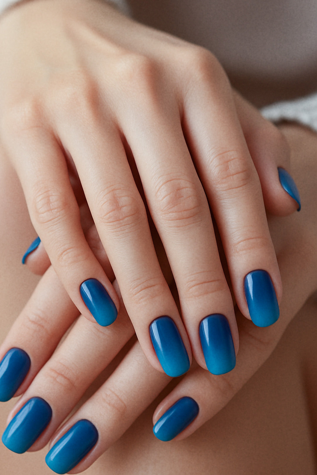 A model’s hand styled with Ocean Dip Ombre Nail Stickies, showcasing a seamless gradient from deep navy blue to vibrant aqua teal, highlighting the bold contrast of ocean-inspired tones while adding a sleek, glossy finish that elevates simple nail art into a polished statement – Muselot.