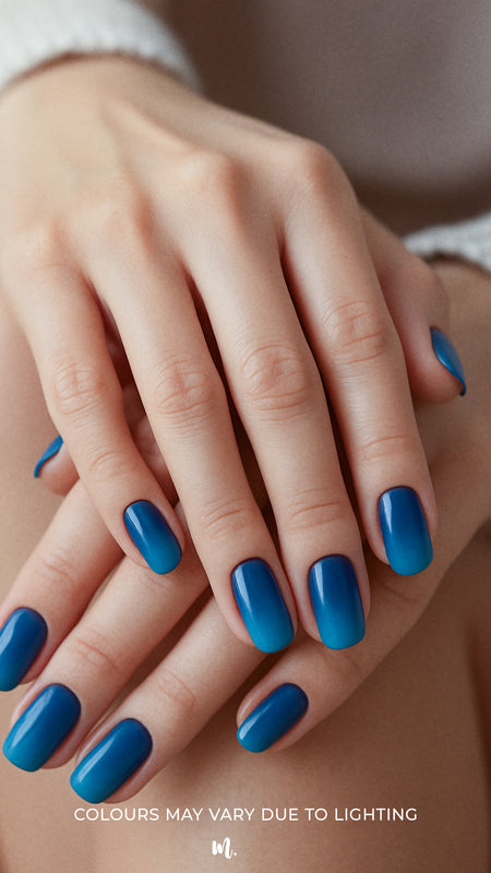 A model’s hand styled with Ocean Dip Ombre Nail Stickies, showcasing a seamless gradient from deep navy blue to vibrant aqua teal, highlighting the bold contrast of ocean-inspired tones while adding a sleek, glossy finish that elevates simple nail art into a polished statement – Muselot.