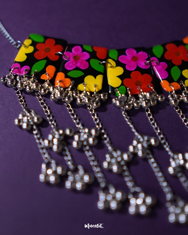 A zoomed-in view of the Parizad floral jewelry set focusing on the silver-toned chains and gungroo drops. The hanging details create a rhythmic movement and add a festive charm to the handcrafted floral neckpiece — Muselot