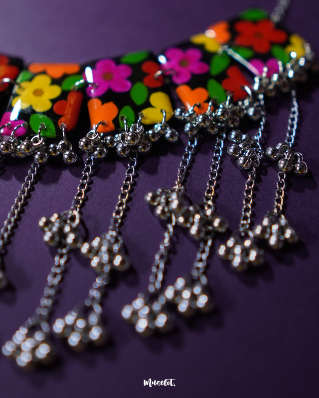 A detailed view of the Parizad floral jewelry set highlighting the silver chains and gungroo danglers. The cascading layers add movement and charm, making the necklace perfect for adding a touch of playfulness to any look — Muselot