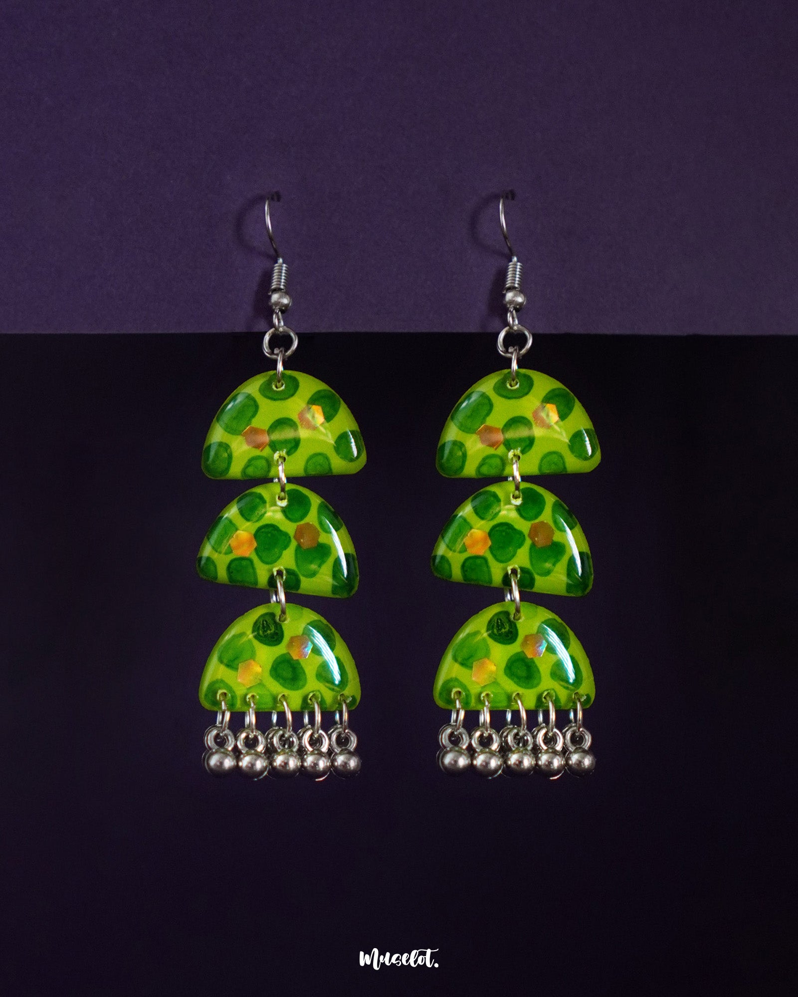 Parvaaz green drop earrings crafted in a triple-tier semicircle design, featuring hand-painted leafy dot patterns in fresh green tones, highlighting their bold rhythm and showcasing a vibrant twist on traditional charm — Muselot.