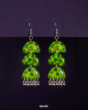Parvaaz green drop earrings crafted in a triple-tier semicircle design, featuring hand-painted leafy dot patterns in fresh green tones, highlighting their bold rhythm and showcasing a vibrant twist on traditional charm — Muselot.