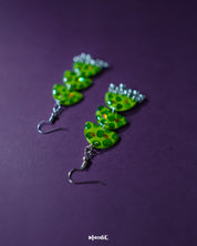 A close-up of Parvaaz green drop earrings featuring delicate dark green dot detailing on a rich green base, highlighting their earthy tones and minimalist handmade charm — Muselot.