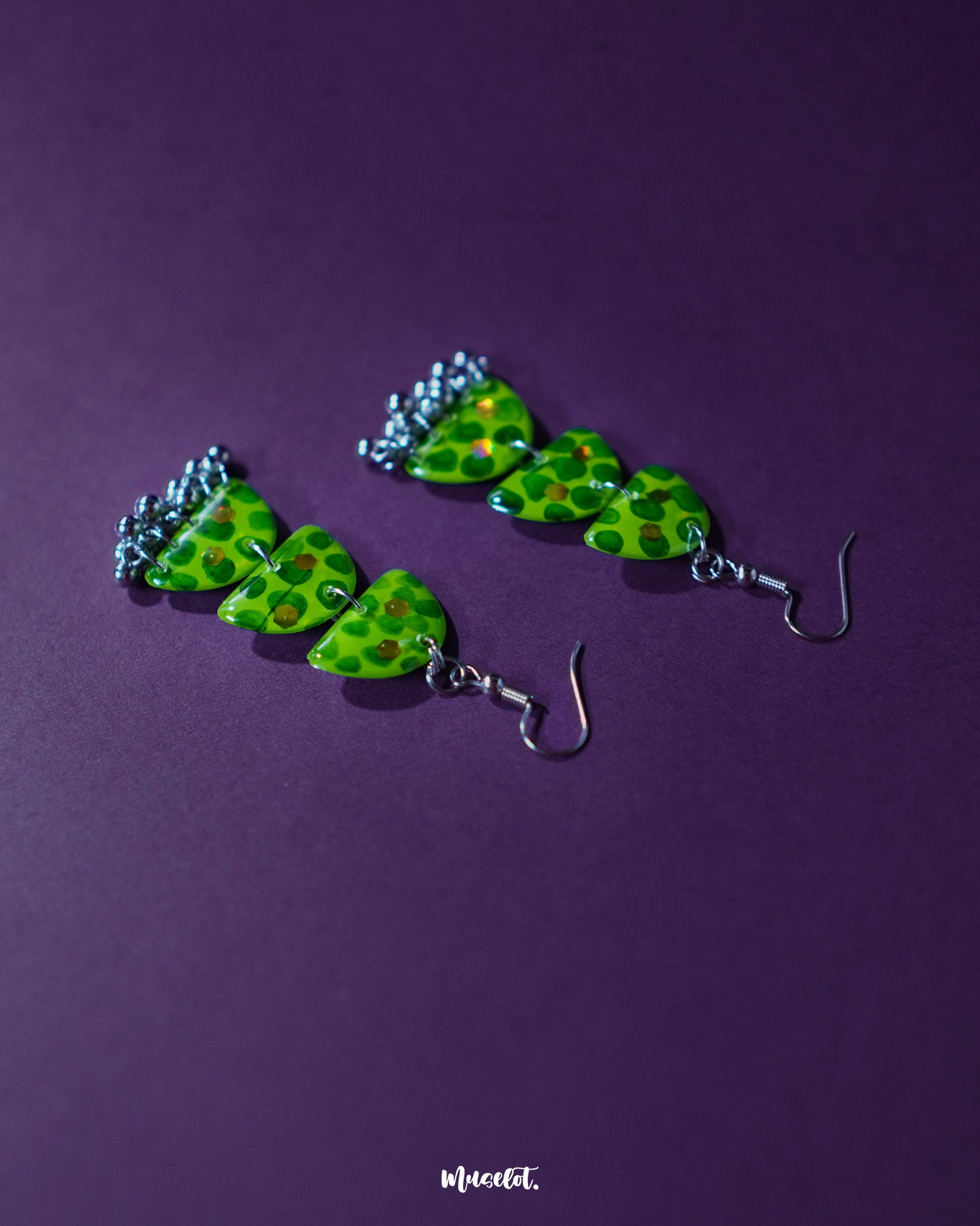 Parvaaz green drop earrings featuring a teardrop silhouette with hand-painted dark green dotted accents on a pale green base, showcasing the handmade finesse and nature-inspired elegance — Muselot.
