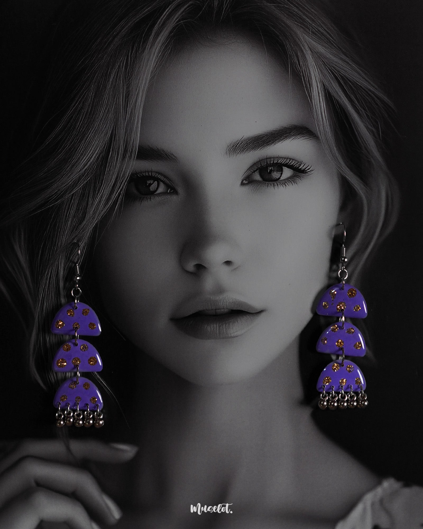 A woman wearing the Parvaaz handmade purple drop earrings, with delicate motifs and an elegant curved shape, highlighting the intricate craftsmanship and showcasing how effortlessly they add charm to a contemporary look — Muselot.