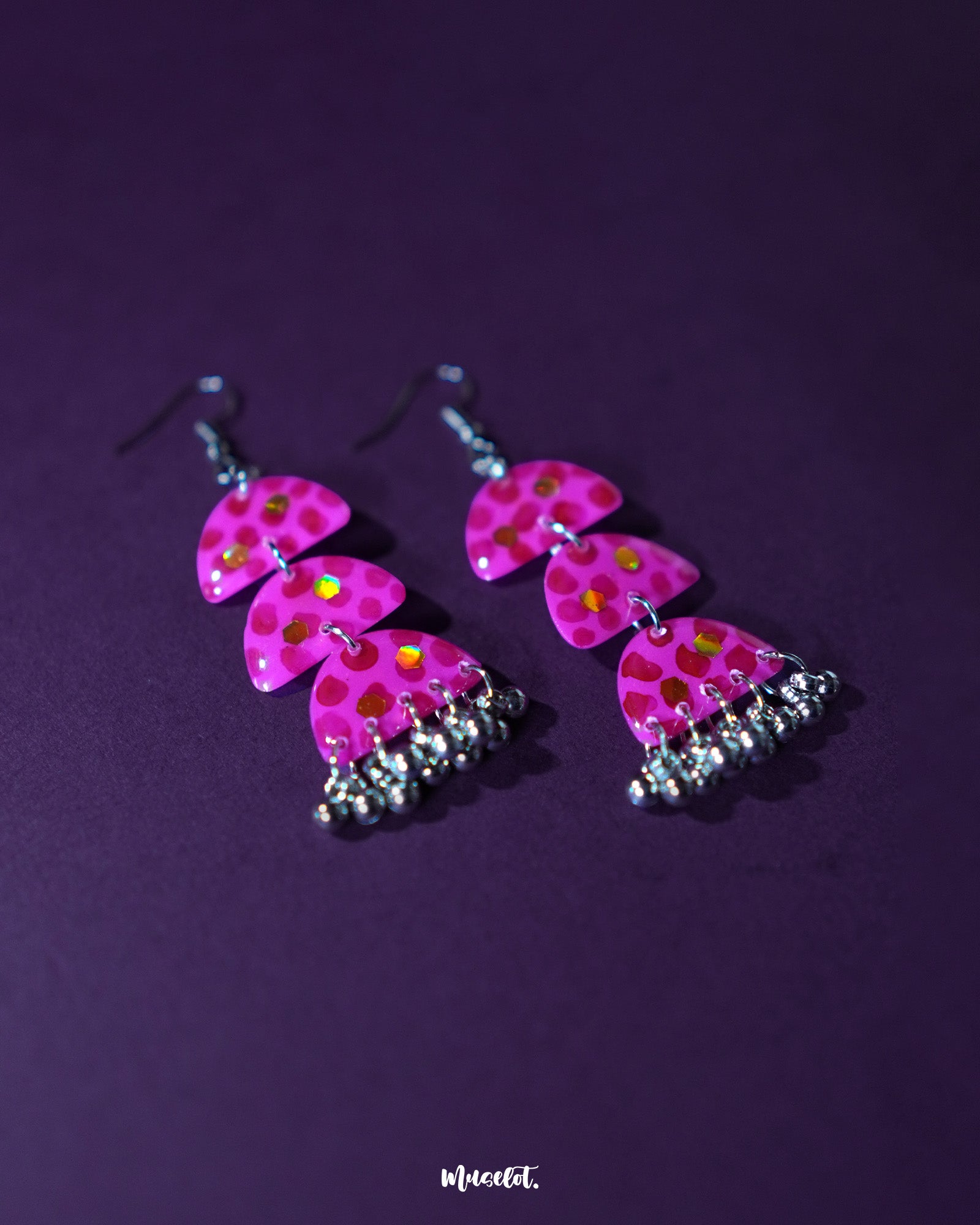 Close-up view of Parvaaz pink drop earrings, featuring hand-painted floral accents with a soft sheen, highlighting their intricate craftsmanship and showcasing an elegant handcrafted charm — Muselot.