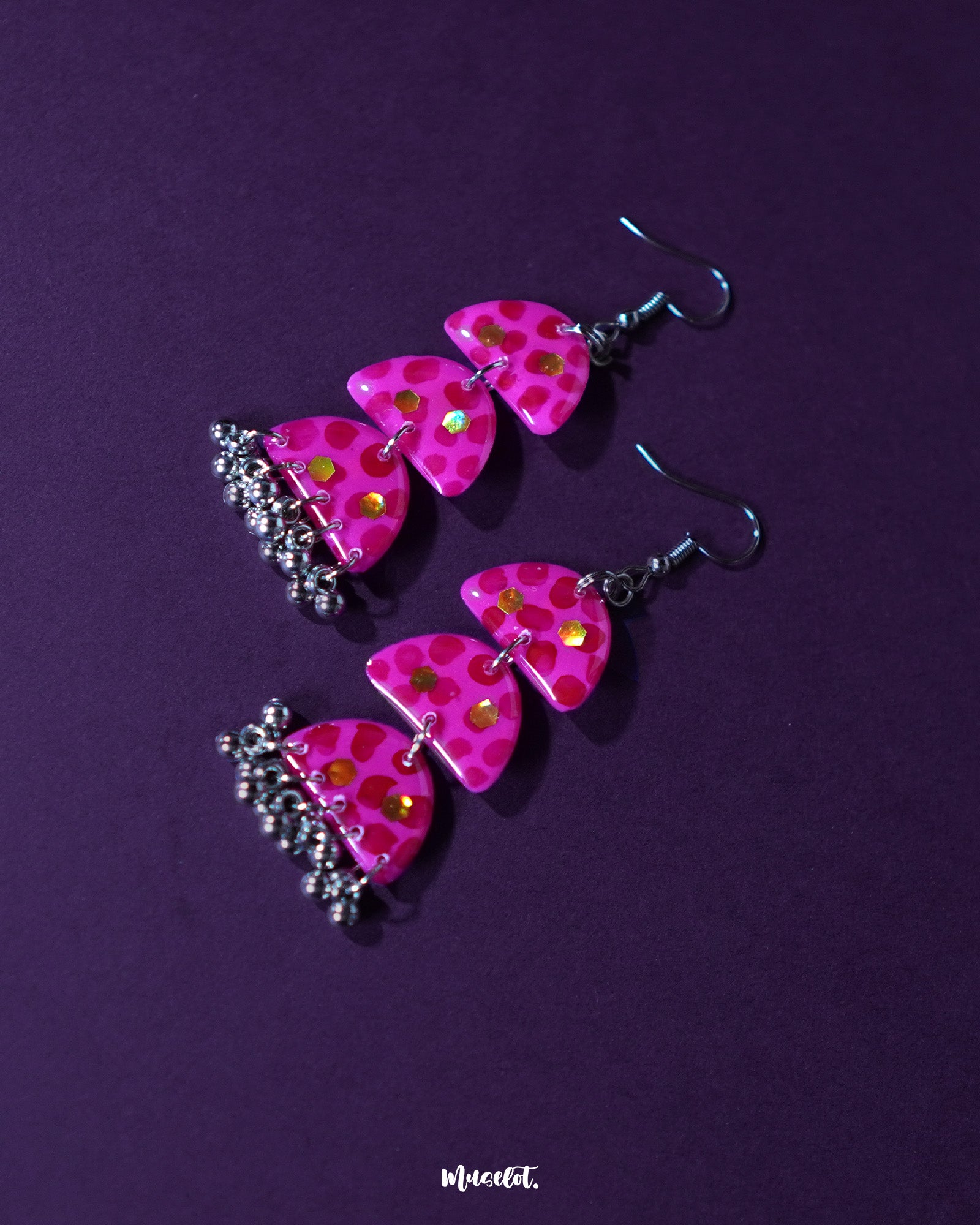 Close-up view of Parvaaz pink drop earrings featuring intricate floral detailing and a soft, glossy finish, highlighting the craftsmanship and showcasing the feminine charm of handcrafted accessories — Muselot.