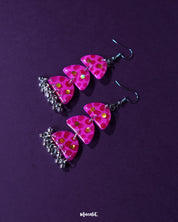 Close-up view of Parvaaz pink drop earrings featuring intricate floral detailing and a soft, glossy finish, highlighting the craftsmanship and showcasing the feminine charm of handcrafted accessories — Muselot.