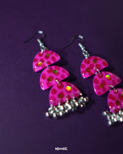A detailed shot of Parvaaz pink drop earrings with delicately hand-painted petals and subtle shimmer, highlighting their elegant floral shape and showcasing the handcrafted finesse — Muselot.