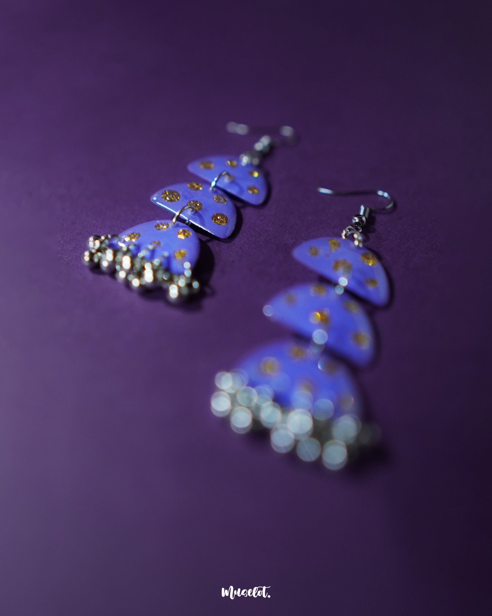 Parvaaz purple drop earrings in a teardrop shape, hand-painted in rich purple with tiny golden dot accents, highlighting the artisanal detail and showcasing a blend of regal charm and minimal elegance — Muselot.