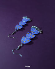 Parvaaz purple drop earrings displayed against a soft backdrop, showcasing their glossy finish and golden dotted accents that highlight the handcrafted finesse and vibrant color play — Muselot.