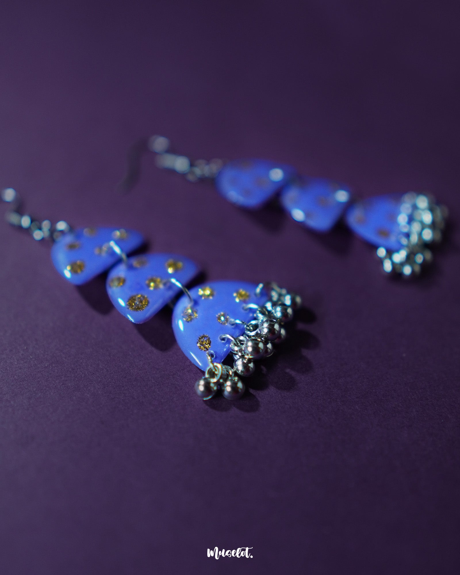 A close-up view of Parvaaz purple drop earrings, featuring a rich purple base adorned with delicate golden dots, highlighting their elegant charm and artisanal detailing — Muselot.