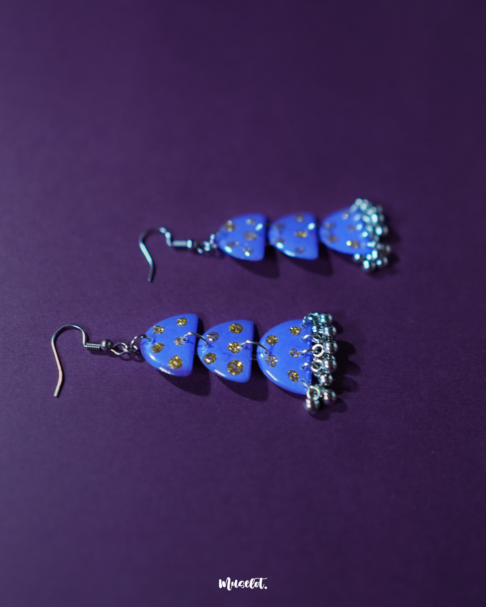 A parvaaz purple drop earrings featuring a smooth matte finish and delicate golden dots, highlighting the elegant teardrop shape and showcasing artisanal detailing with a rich, boho-inspired appeal — Muselot.