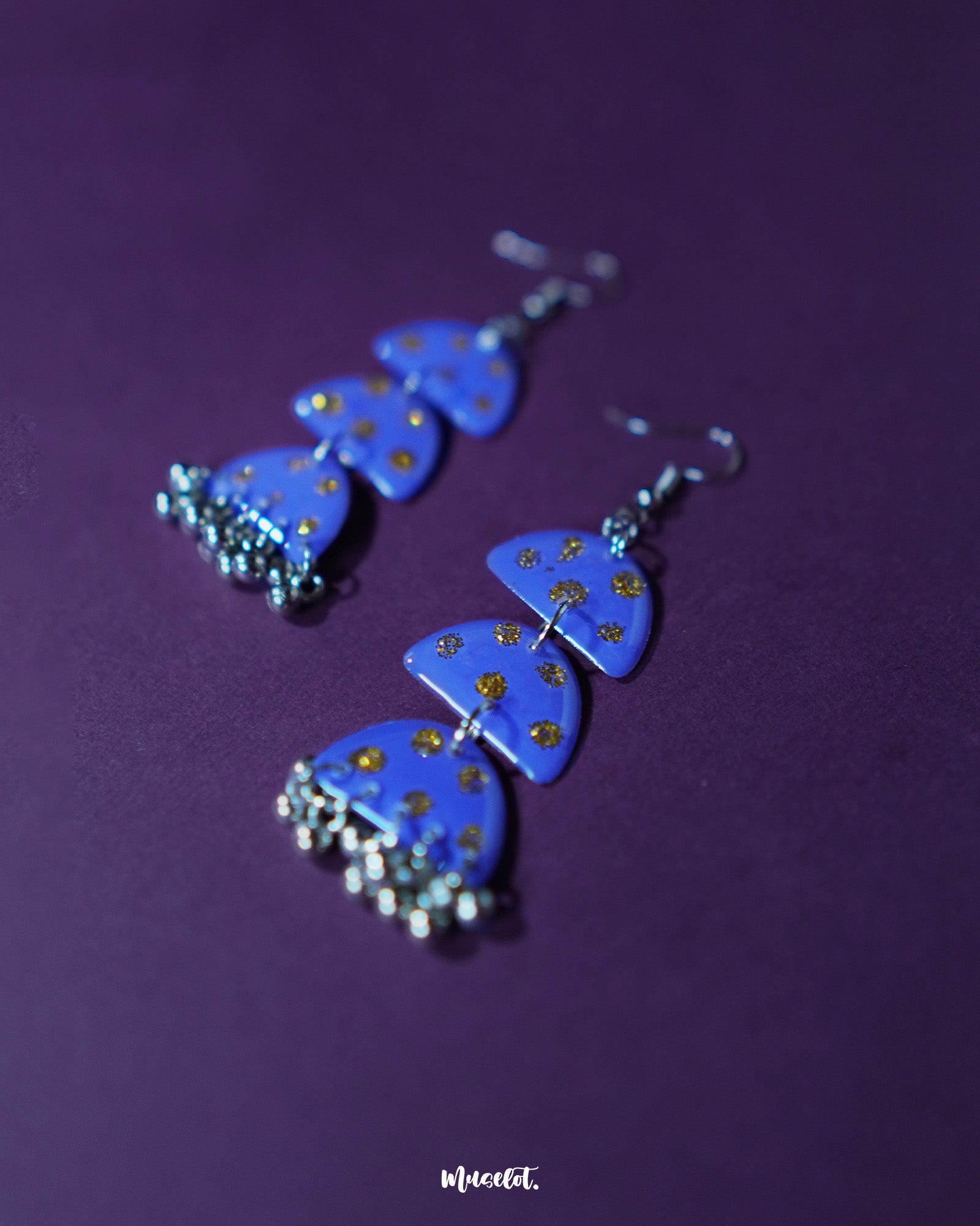 Parvaaz purple drop earrings placed on a neutral surface, showcasing the handcrafted teardrop design with subtle golden dot accents that highlight the artisanal charm and refined elegance — Muselot.