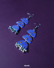 Parvaaz purple drop earrings placed on a neutral surface, showcasing the handcrafted teardrop design with subtle golden dot accents that highlight the artisanal charm and refined elegance — Muselot.