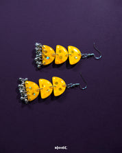 A detailed view of Parvaaz yellow drop earrings with delicate yellow flowers, highlighting the intricate hand-painted design and showcasing the vibrant charm and artisan finesse — Muselot.