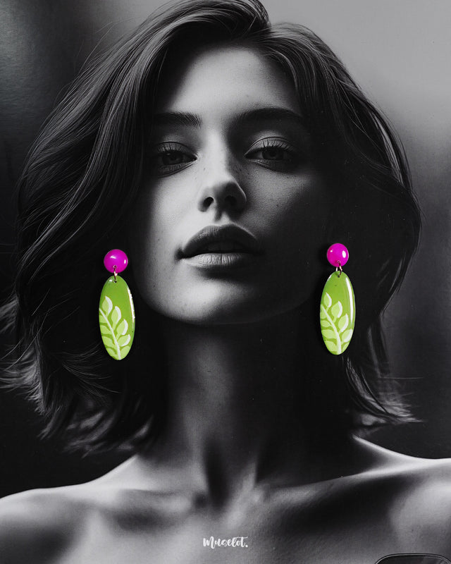Patbaan leaf drop earrings worn by the model, showcasing their vibrant green body with white hand-painted leaf patterns and striking pink studs — a playful nod to nature, styled with contemporary flair — Muselot.