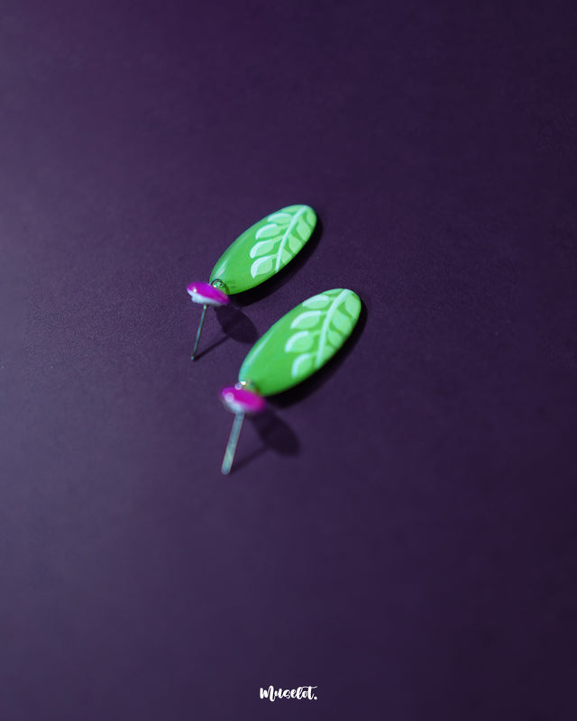 Patbaan drop earrings highlighting the delicate leaf-inspired carving on the glossy green drop and showcasing the bold contrast with the fuchsia pink stud. The handcrafted finish and vibrant tones emphasize their artisanal charm and statement-worthy elegance — Muselot.