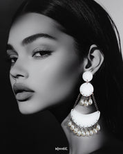 A woman wearing pearl handmade chandbali earrings, showcasing their crescent-shaped white base with dangling pearls and delicate silver chains, highlighting the serene charm of artisanal jewelry — Muselot.