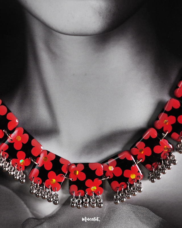 A close up shot of a Raktphool jewelry set, showcasing its intricate floral design, is displayed against a subtle purple background, enhancing the elegance and beauty of this exquisite piece — Muselot.