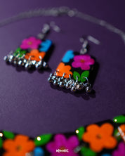 Close-up view of the earrings from the Rangbaagh black floral necklace set, showcasing the delicate floral detailing, glossy black finish, and intricate handcrafted design elements — Muselot
