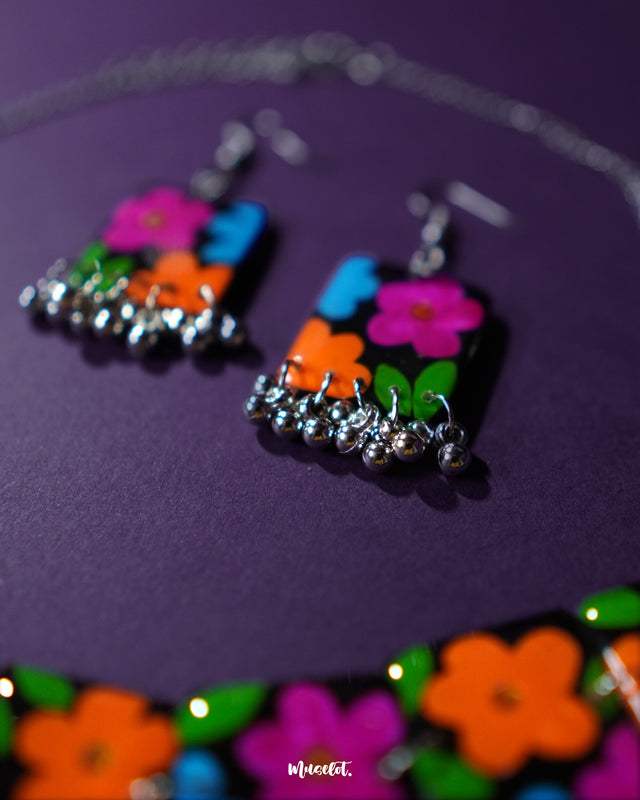Close-up view of the earrings from the Rangbaagh black floral necklace set, showcasing the delicate floral detailing, glossy black finish, and intricate handcrafted design elements — Muselot