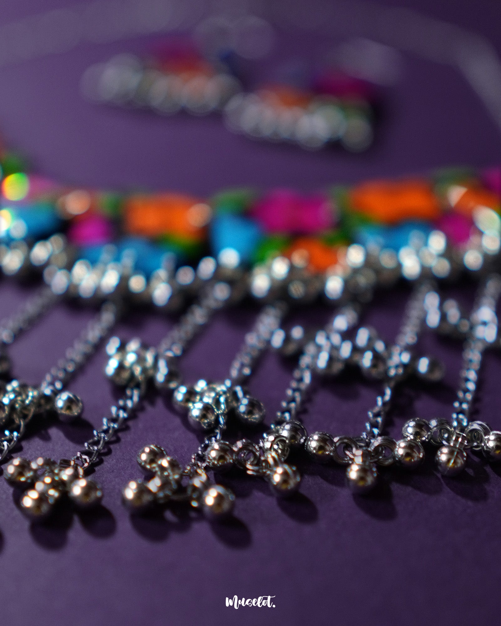 A zoomed-in shot of the Rangbaagh black floral necklace set, highlighting the intricate silver gungroo chain that adds a rhythmic charm and traditional elegance to the overall handcrafted design — Muselot