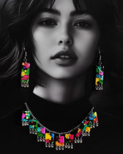 Close-up of a model wearing the Rangbaari colorful necklace set by Muselot, showcasing the vivid multicolor rectangular pendant pieces with silver ghungroos. The intricate blend of greens, pinks, blues, and yellows pops against the model’s skin, highlighting the festive, bohemian aesthetic of the jewelry.