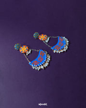 The Ranglahar blue chandbaali earrings displayed against a soft background, featuring intricate enamel detailing in blue and orange with delicate pearl danglings—crafted to add regal charm to festive looks — Muselot.