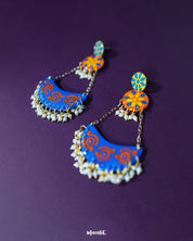 Ranglahar blue chandbaali earrings showcasing a graceful crescent silhouette with intricate detailing and soft pearl embellishments, perfect for elevating festive looks — Muselot.