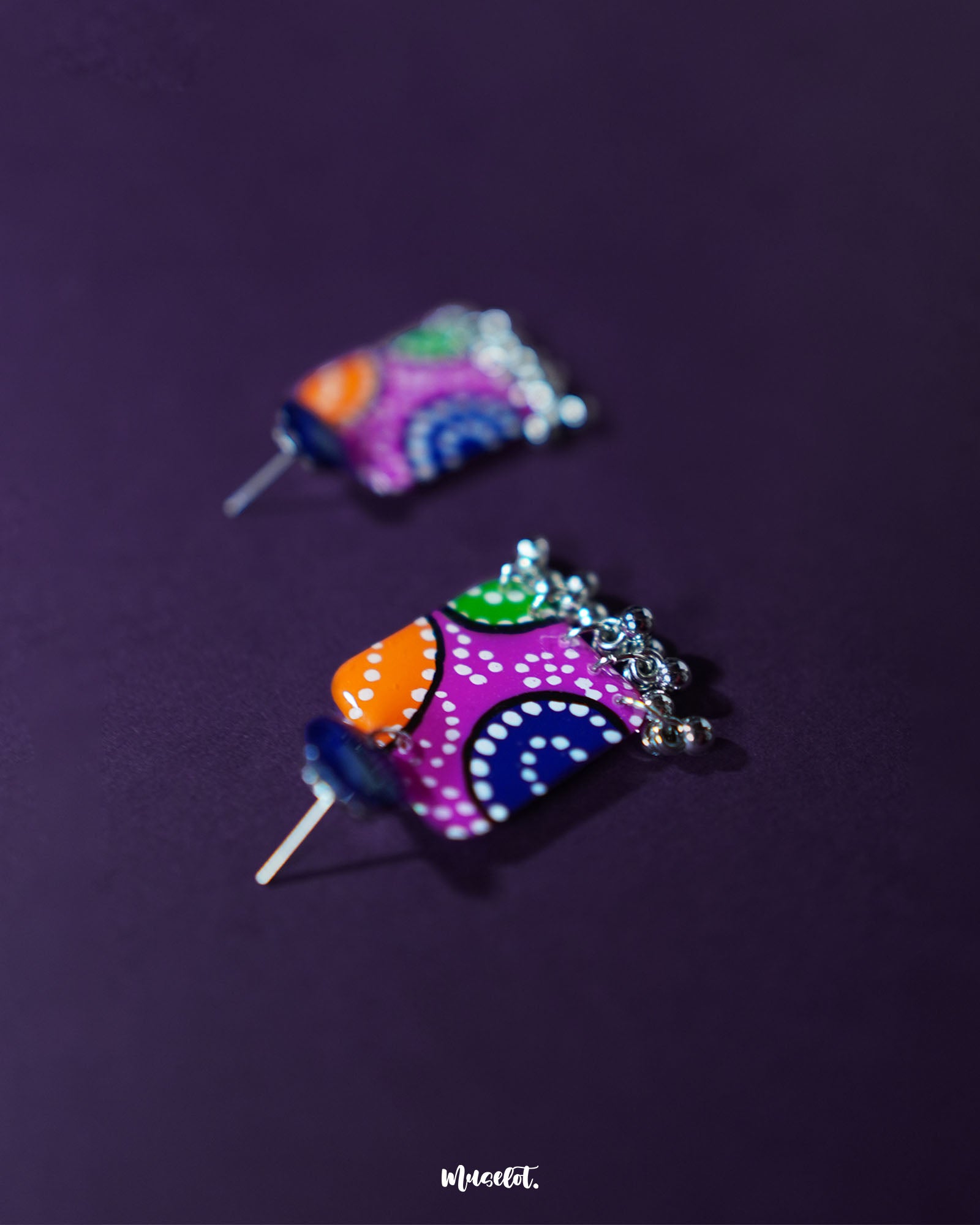 Rangras stud earrings placed elegantly with a focus on their symmetrical folk-art design and multicolored detailing, evoking a charming blend of culture and creativity — Muselot