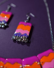 A close-up of the model wearing a single earring from the Rangrezan handmade necklace set reveals the vibrant detailing—multicolored beads, gold-toned accents, and traditional design elements that celebrate the art of Indian craftsmanship — Muselot.