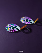 Raushanbahaar floral drop earrings featuring vibrant pink and yellow flowers with green leafy details on a teardrop silhouette, highlighting their vivid colors and showcasing the playful elegance of handcrafted statement pieces — Muselot.