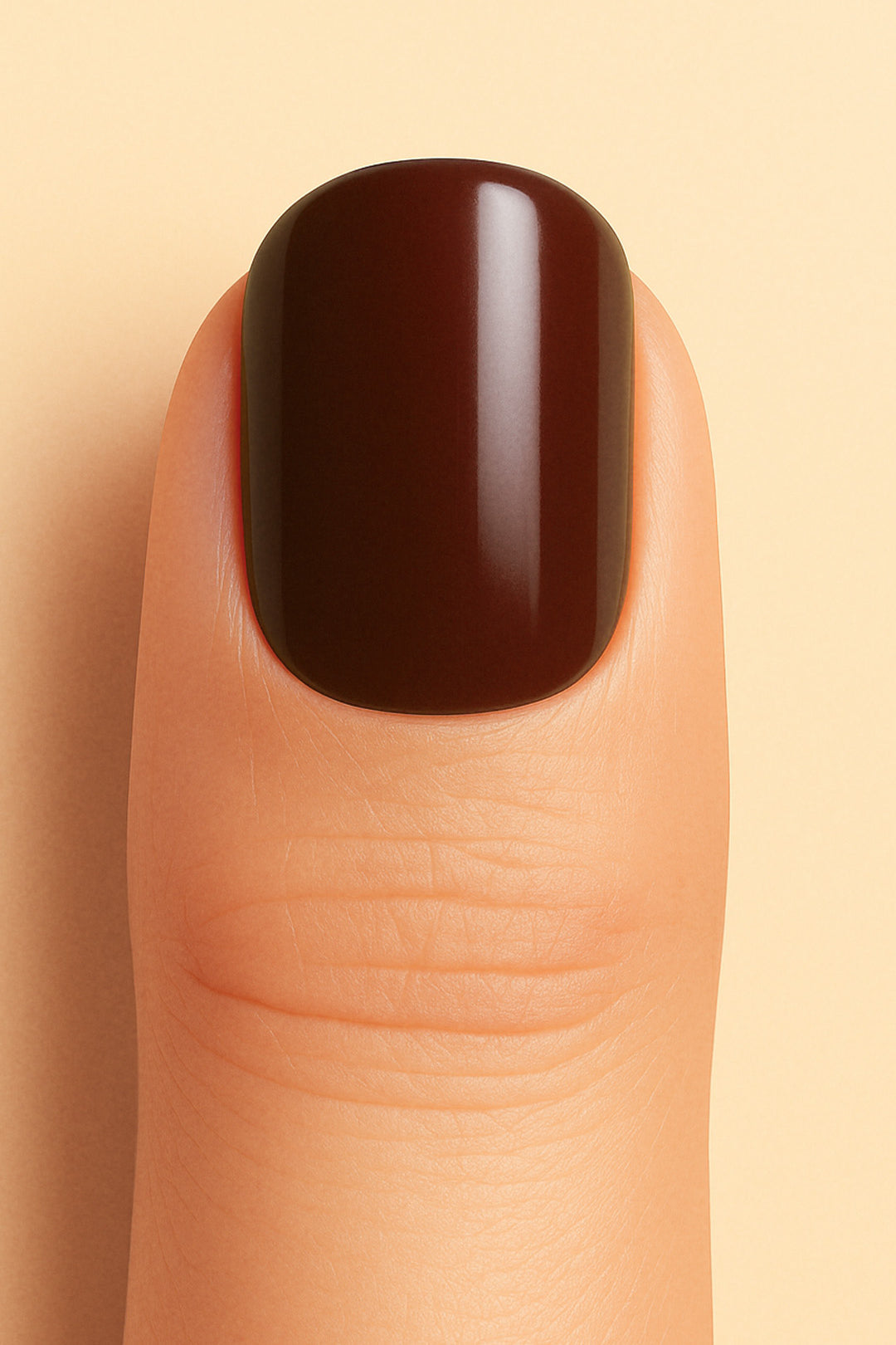 A close-up shot of a model finger wearing Rich Cocoa nail stickies, showcasing the deep chocolate-brown shade with a smooth glossy finish, highlighting the bold sophistication and elegance of minimal solid nail art – Muselot.
