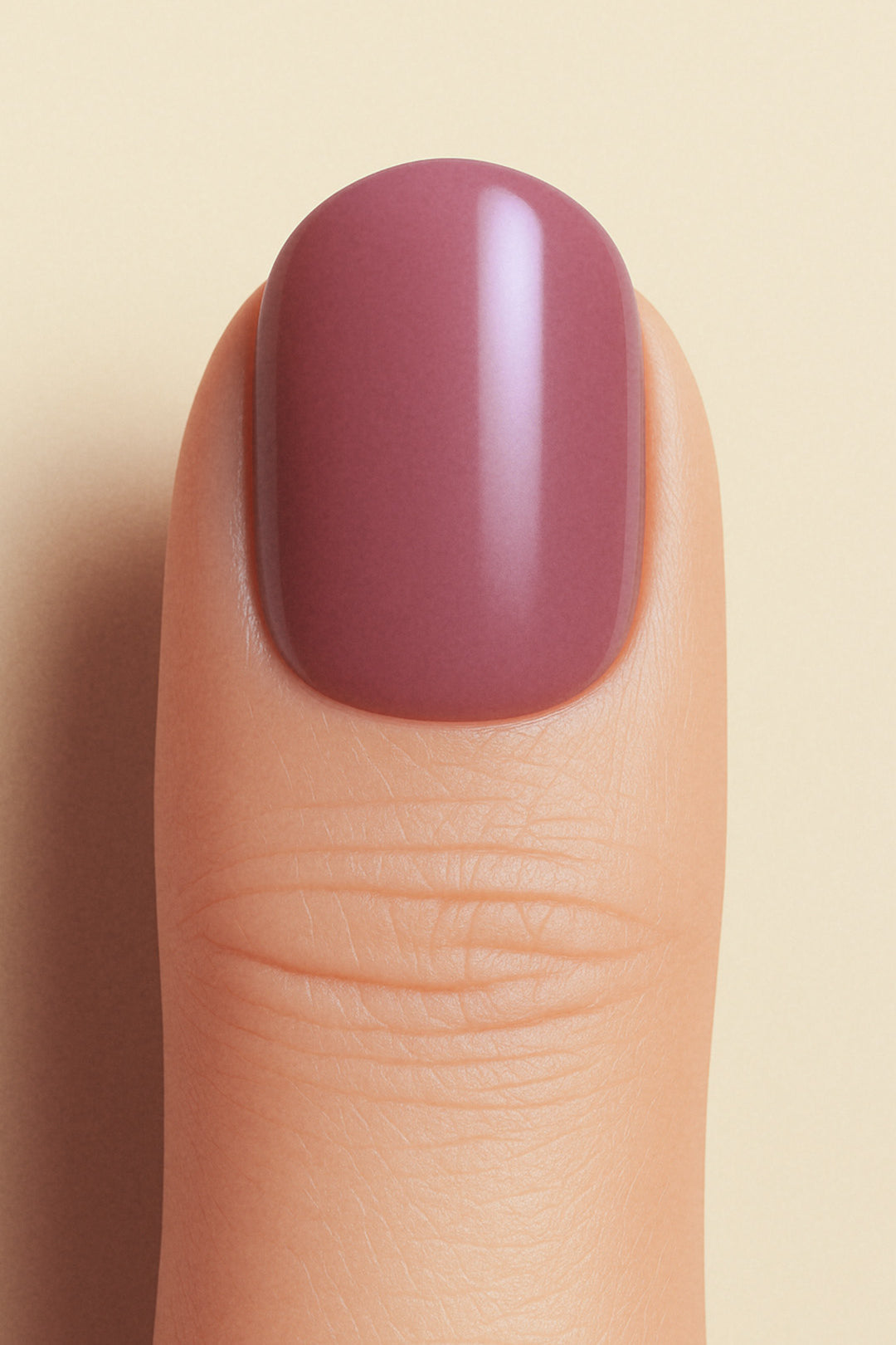 A closeup shot of a model thumb, showcasing a rich mauve shade with a glossy finish, highlighting the elegance of minimal solid color nails-Muselot