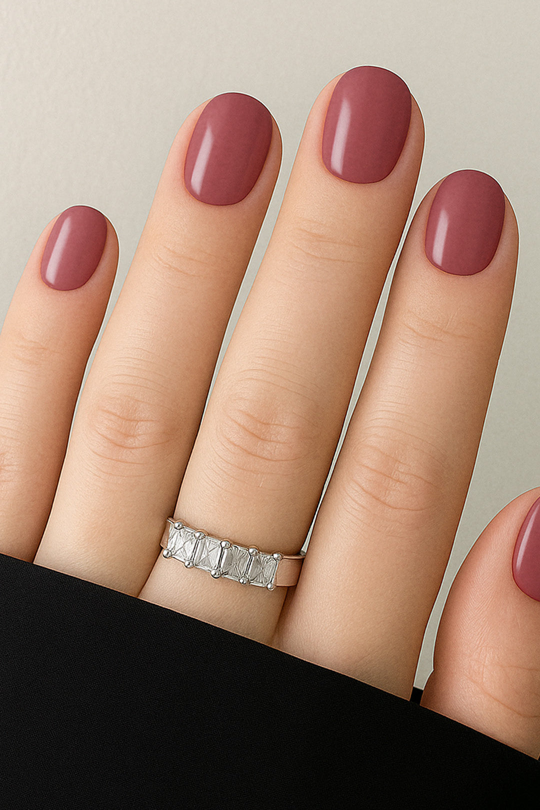 A shot of a model’s hand wearing Rose Clay nail stickies, showcasing the shade in a rich mauve tone with a glossy solid finish, highlighting the elegance of minimal nail art while adding a refined salon-style look – Muselot.