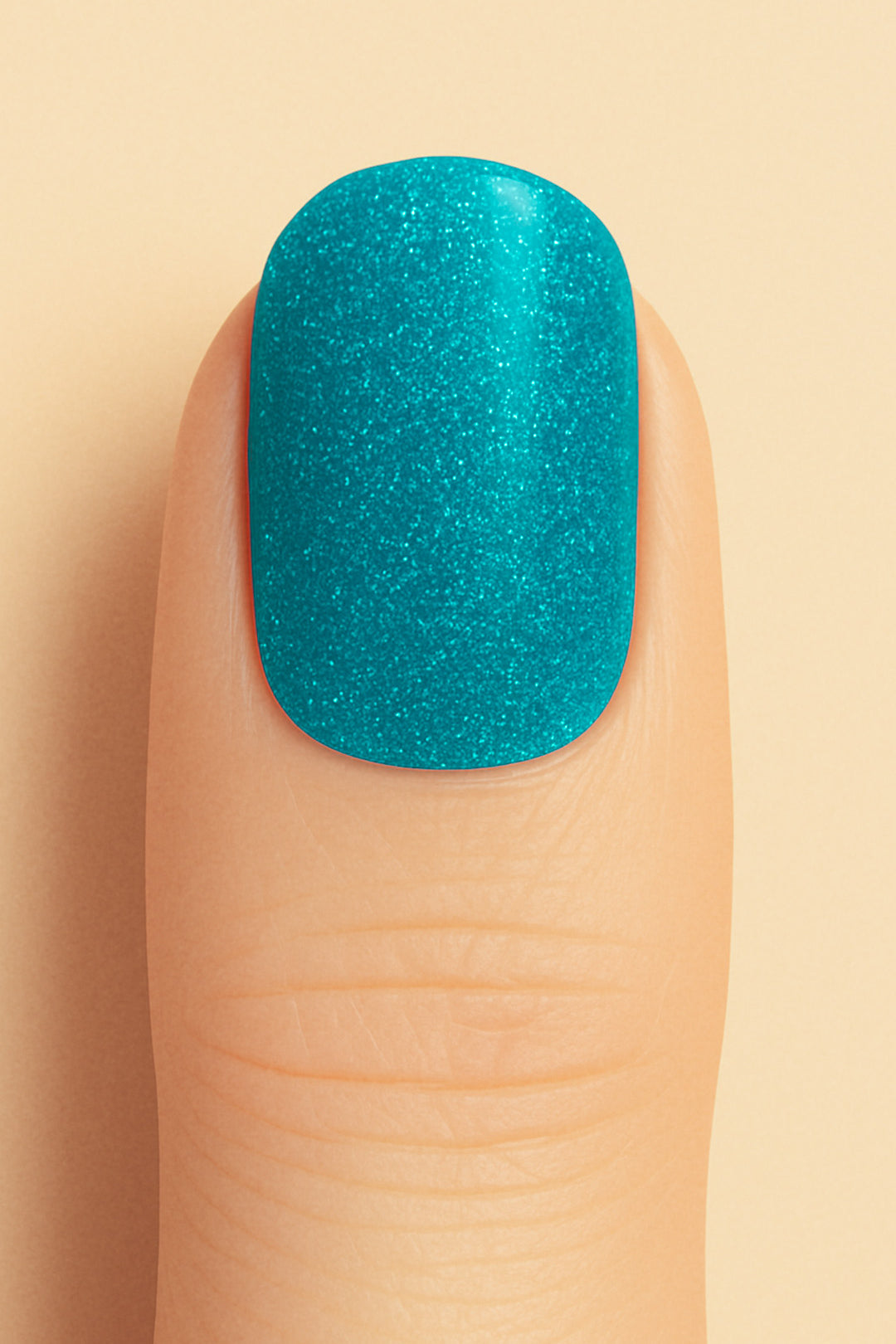 A close-up shot of a model’s finger wearing Sea Spark Glitter nail stickies, showcasing the bright turquoise-blue shade packed with fine glitter shimmer, highlighting the bold sparkle and vibrant charm of glitter nail art with a smooth glossy finish – Muselot.