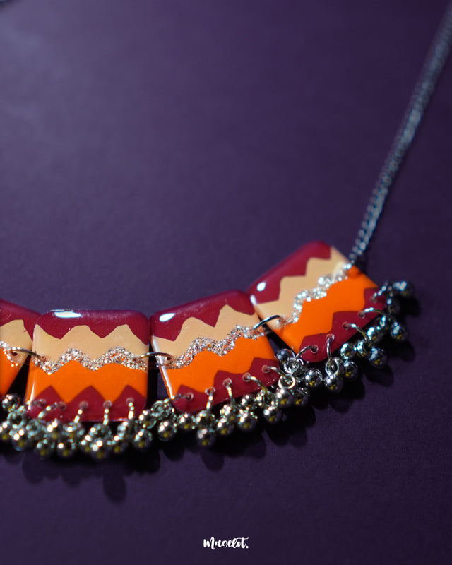 A zoom-in shot of the handmade traditional necklace set against a rich purple background, showcasing the vibrant beadwork, delicate patterns, and expert craftsmanship — Muselot.