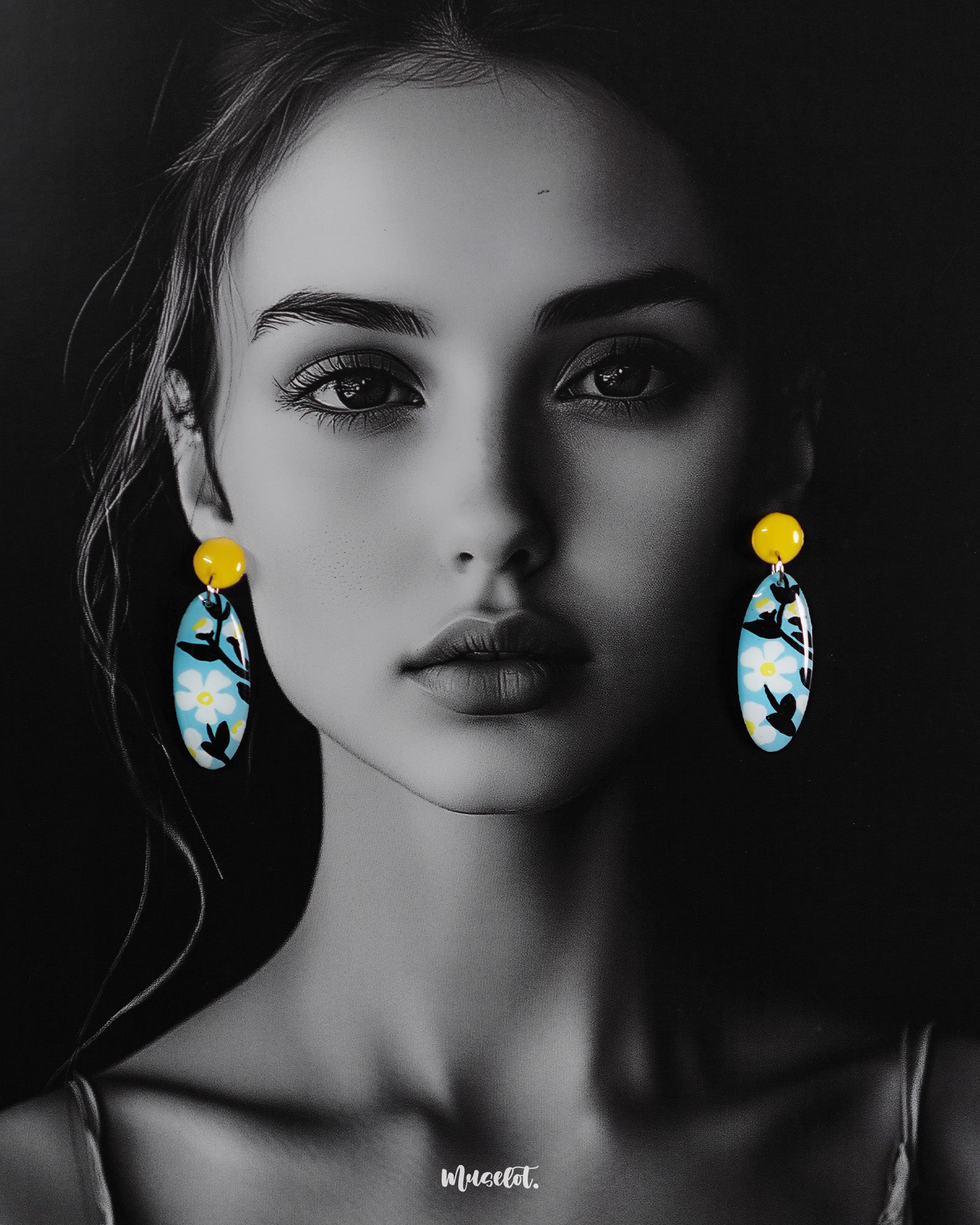 A woman wears the oval-shaped Shaamgul floral drop earrings against a deep purple background, highlighting the sky-blue base, white daisies, black leaves, and yellow stud—beautifully showcasing their handmade charm and standout design — Muselot.