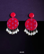 Shabnam pink pearl drop earrings featuring round hot pink studs with soft lilac geometric motifs and dangling white pearl beads, showcasing vibrant femininity and highlighting graceful movement — Muselot.
