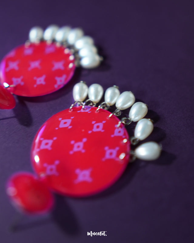 A close up shot of Shabnam pink pearl drop earrings featuring a bold circular design with soft pink geometric prints and delicate pearl-like drops, highlighting elegance and showcasing handcrafted charm — Muselot.