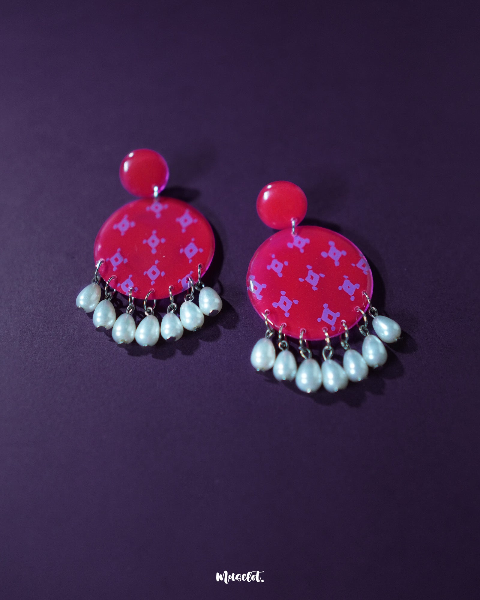 Shabnam pink pearl drop earrings laid out neatly on a soft neutral background, showcasing the glossy pink studs paired with delicate white pearl drops, highlighting their graceful charm and handcrafted elegance — Muselot.