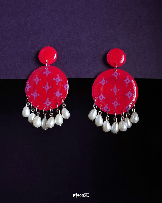 Shabnam pink pearl drop earrings featuring round hot pink studs with soft lilac geometric motifs and dangling white pearl beads, showcasing vibrant femininity and highlighting graceful movement — Muselot.