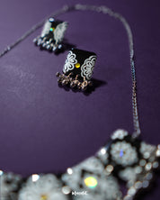 Close-up of the Shabnoor black floral jewelry set displayed on a neutral backdrop, showcasing the delicate hand-painted black flowers and fine detailing of the matching necklace and earrings — Muselot.