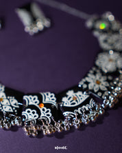 A zoomed-in view of the Shabnoor black floral jewelry set, focusing on the fine petal detailing and textured finish of the handcrafted flowers, showcasing the intricate artistry and elegance — Muselot