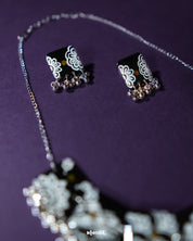A detailed close-up of Shabnoor black floral earrings from the jewelry set, highlighting the delicate craftsmanship and elegant black floral design that adds a timeless touch — Muselot.