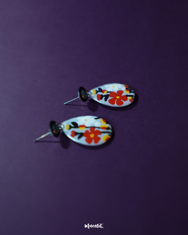 A detailed view of the Shafaq floral earrings capturing the intricate floral craftsmanship and glossy finish, highlighting their artisanal beauty and elegant appeal — Muselot.