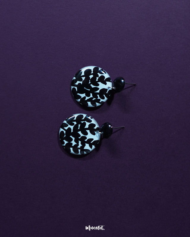 Siyahgul black floral stud earrings, showcased against a rich purple backdrop, with detailed floral motifs and a deep black tone that highlight their bold yet graceful boho elegance — Muselot.