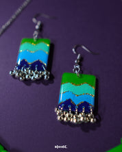 A zoomed-in shot of the Sukoon waterfall boho earrings, highlighting the intricate silver-toned chainwork and enamel detailing in soft green and blue hues. The close-up showcases the fine craftsmanship and bohemian charm — Muselot.